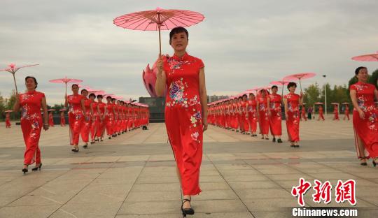 江西省泰和县老年体协旗袍协会会员在泰和县市民广场进行旗袍秀展示。　邓和平 摄