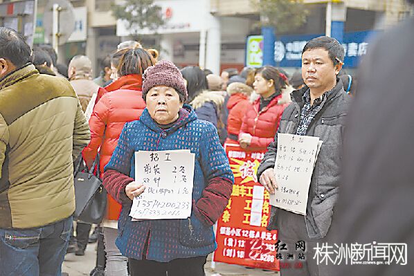 东湖桥边招聘现场，许多招聘者拿着牌子在寻找应聘者 记者 张媛 摄